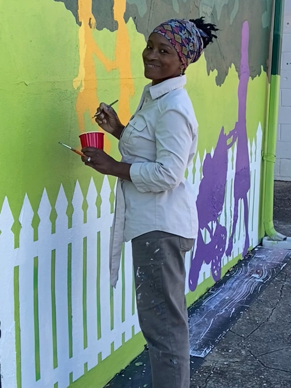 Wall mural artist Emida Roller smiles as she works on one of her projects for a client. 