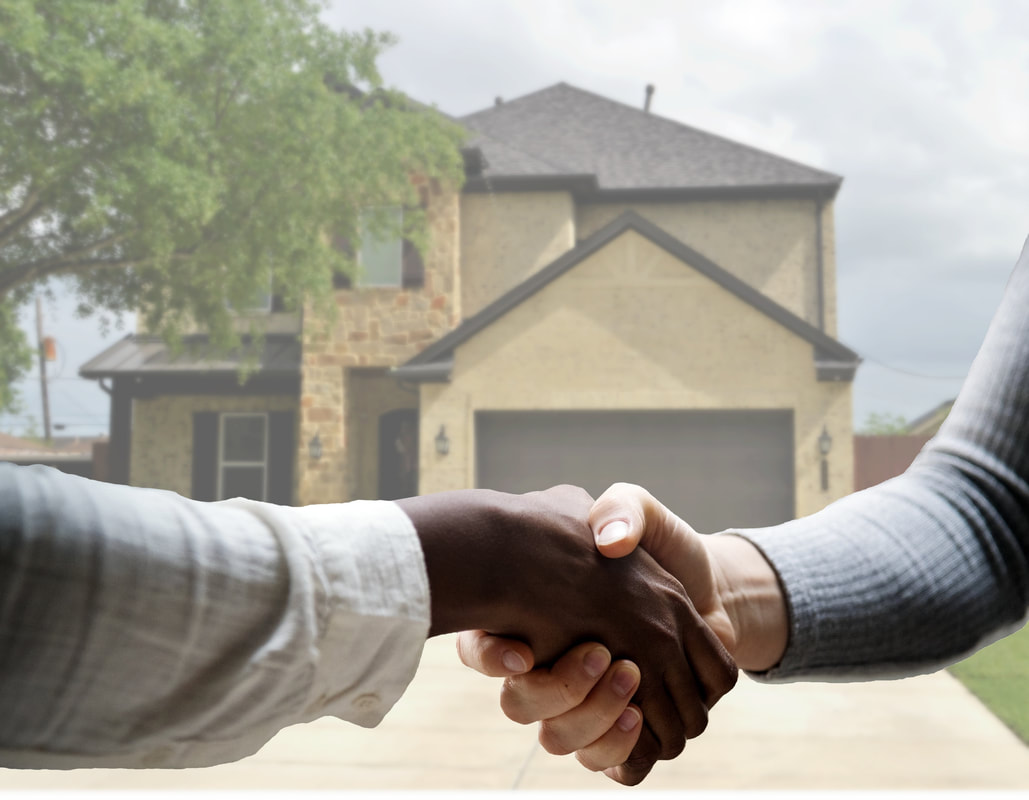 Photo of two people shaking hands over a sold home/real estate property. 