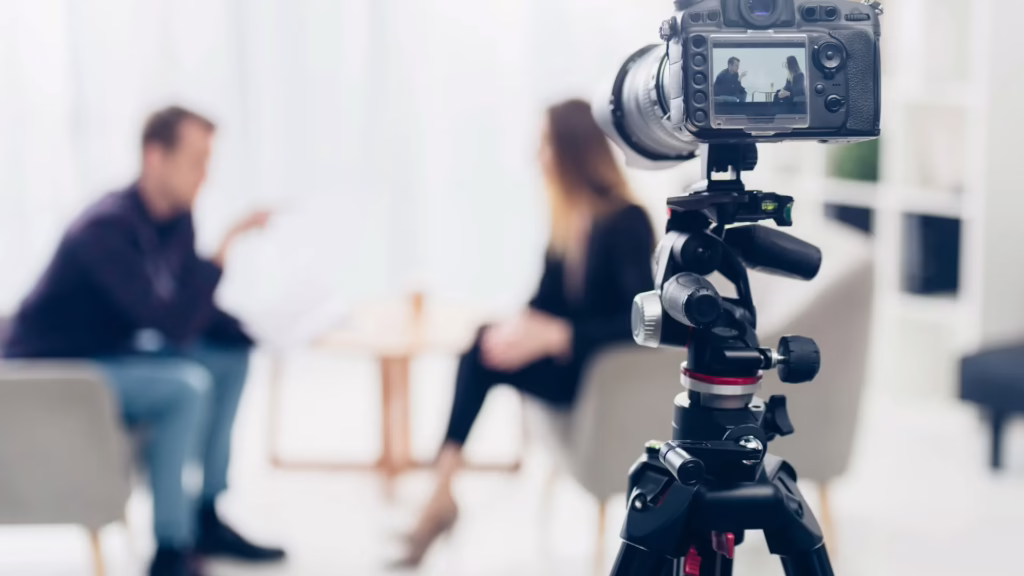 A camera is recording an interview with a content creator and the interview subject. 