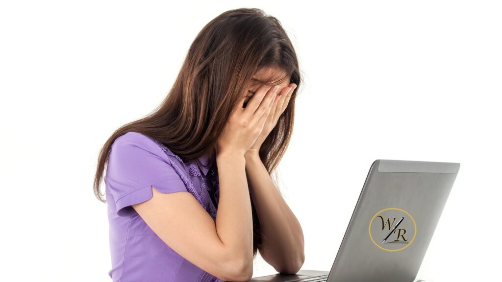 A frustrated woman sitting at her computer trying to prove she's human.